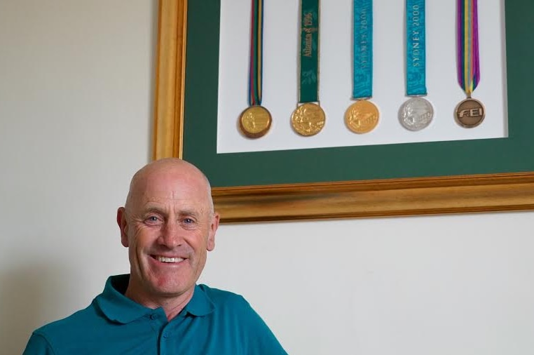 Australia's Andrew Hoy stands next to his four Olympic medals and one World Equestrian Games medal.