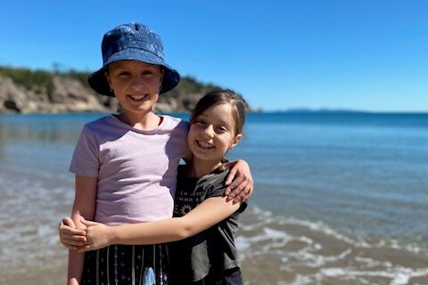 Cystic Fibrosis sufferer Evie Sawyer and her younger sister Matilda standing at the beach.
