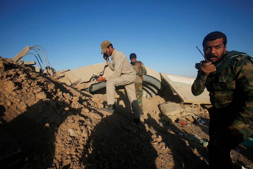 Members of the Shiite Badr Organisation fighters take cover