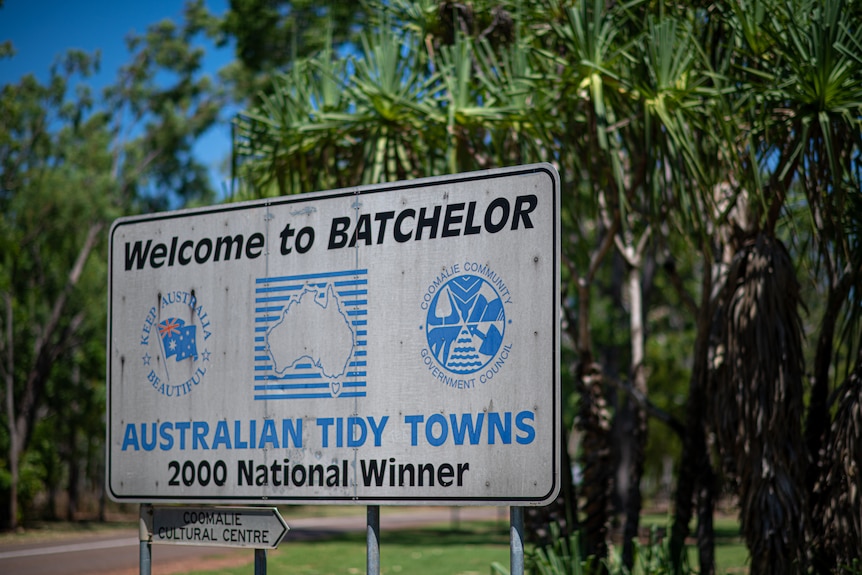 A blue and white sign welcoming people to the Northern Territory town of Batchelor. 