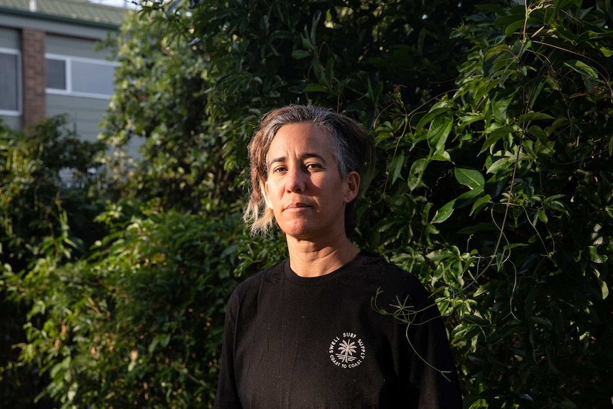 Portrait of Amee standing in front of a garden.