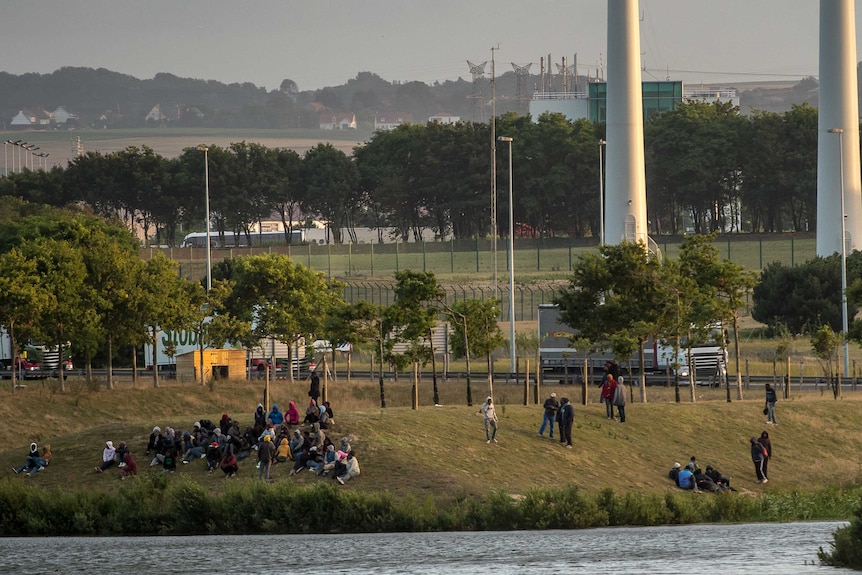 Migrants gather near the Eurotunnel terminal to try to climb in a shuttle heading to Great Britain