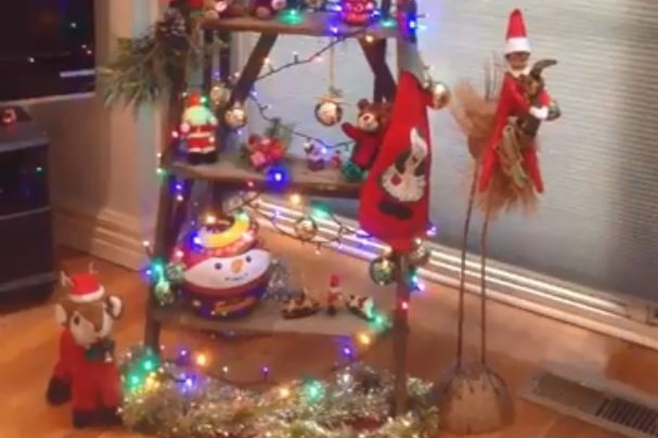A ladder covered in Christmas decorations and figurines.