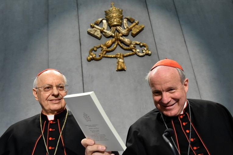 Cardinals Lorenzo Baldisseri and Christoph Schonborn pose with a copy of 'Amoris Laetitia' at the Vatican.