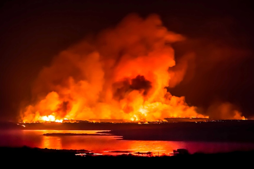 The glow from a fire in the Lincoln National Park, South Australia, fills the night sky.