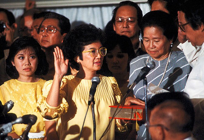 Corazon Aquino takes the oath of office in front of a crowd.