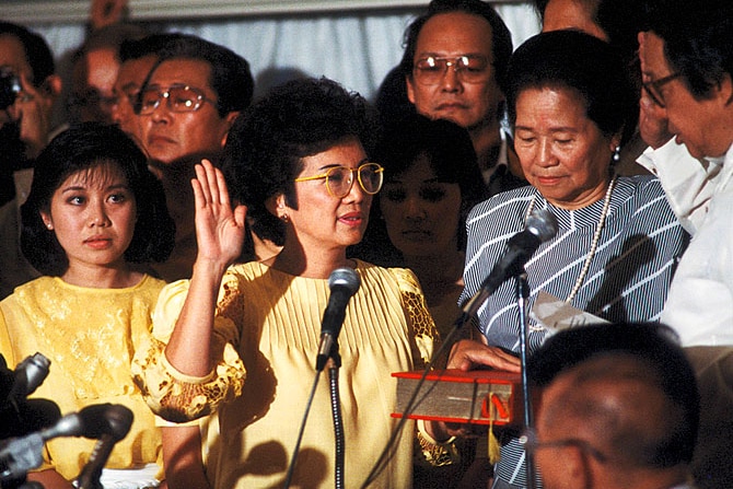 Corazon Aquino takes the oath of office in front of a crowd.