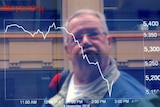 An investor reacts as he looks through a window at boards displaying stock prices at the ASX