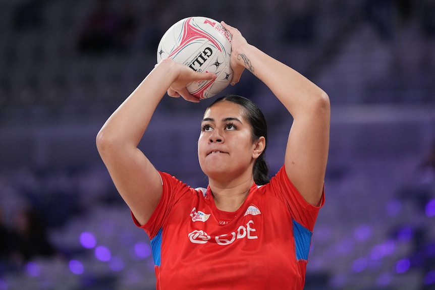 Palavi holds the ball above her head and looks to practice shooting in the warm-up