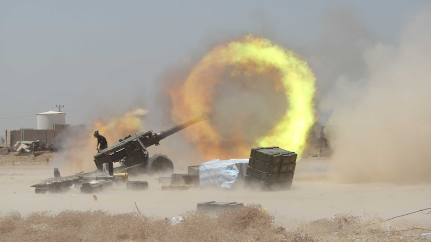 An Iraqi Shiite fighter fires artillery during clashes with Islamic State militants.