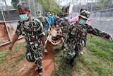 A sedated tiger is stretchered as officials continue moving live tigers from the controversial Tiger Temple.