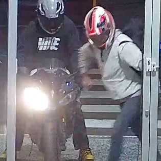 A still image taken from CCTV footage showing two burglars breaking into a shopping centre with one on a bike.
