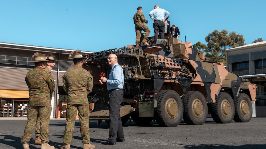 German defence officials climb on a Boxer army vehicle in australia