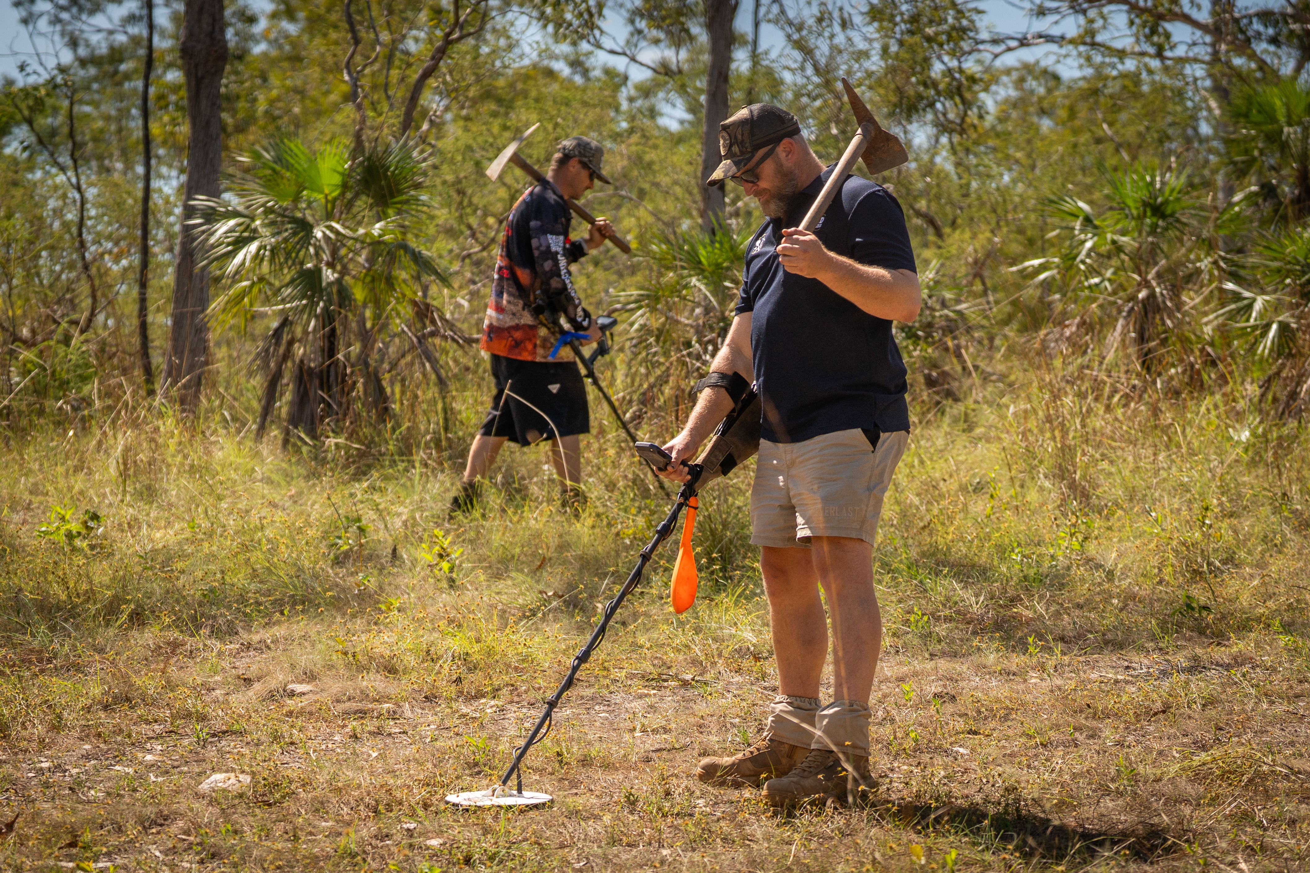 To men prospecting with detectors and mattocks in the bush 
