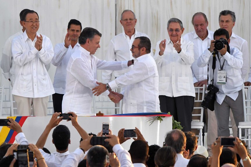 Colombian President Juan Manuel Santos shakes hands with head of the FARC guerrilla Timoleon Jimenez, aka Timochenko.