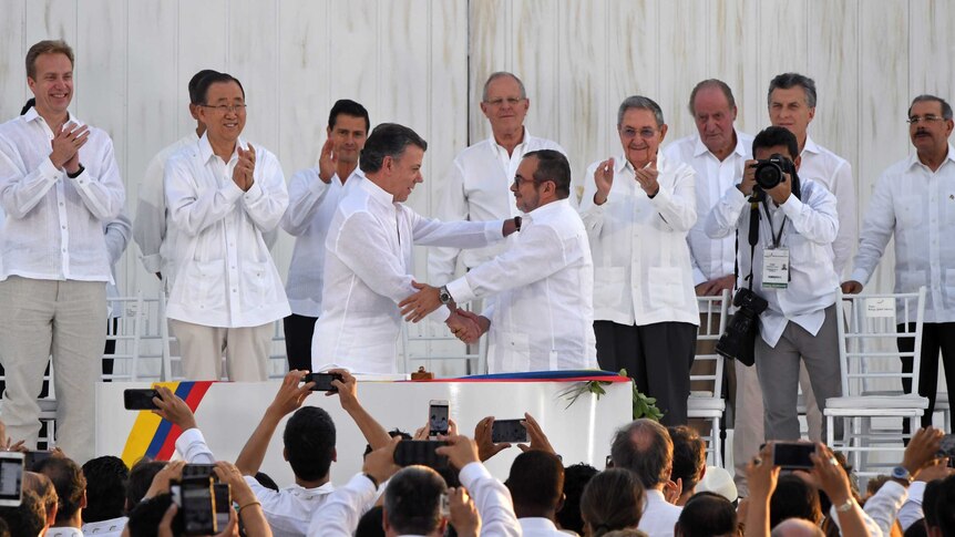 Colombian President Juan Manuel Santos shakes hands with head of the FARC guerrilla Timoleon Jimenez, aka Timochenko.