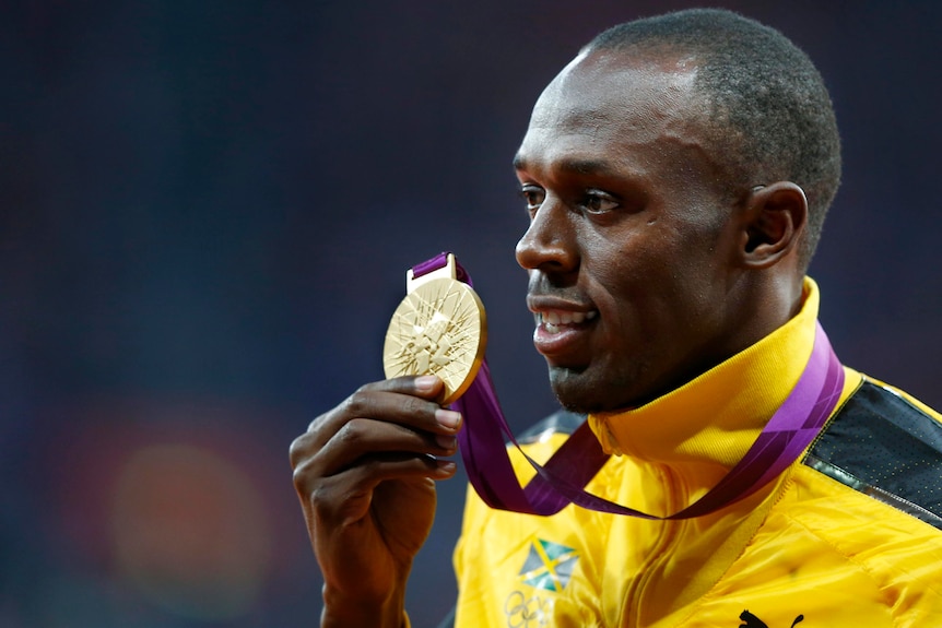 Usain Bolt holds his gold medal during the men's 100m victory ceremony at the London Olympic Games.