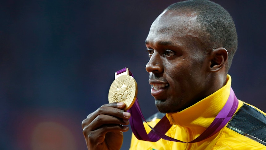 Usain Bolt holds his gold medal during the men's 100m victory ceremony at the London Olympic Games.