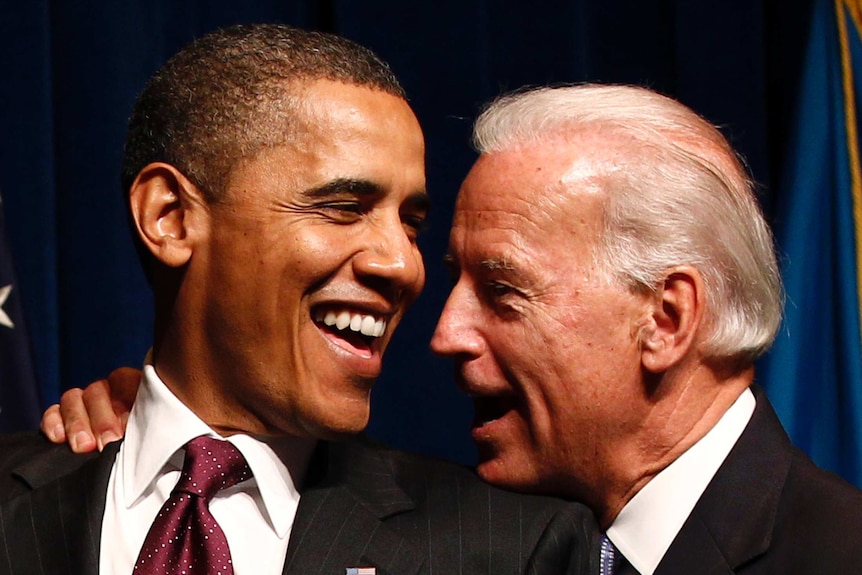 Barack Obama laughs while Joe Biden puts his hand on his shoulder