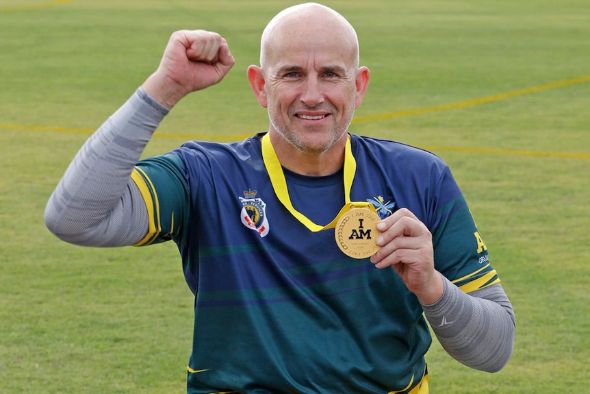Mark Urquhart holds one of his three gold medals won at the Invictus Games in Orlando.
