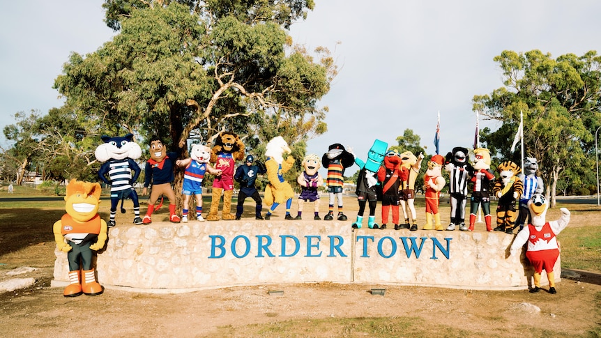 AFL mascots standing on a concrete sign saying BORDERTOWN