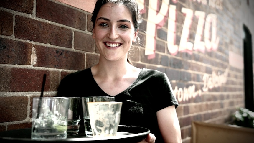 A woman holds a plate standing.