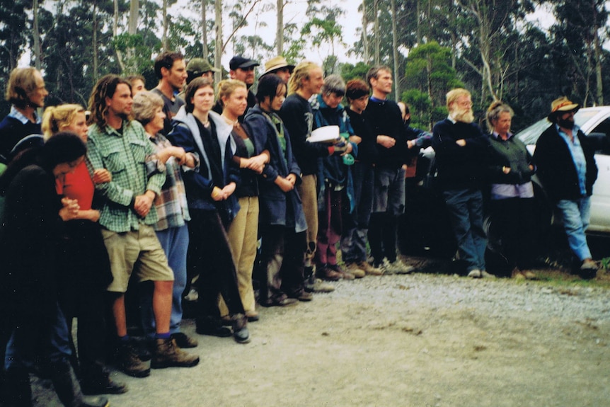 a group of protesters stand arm in arm