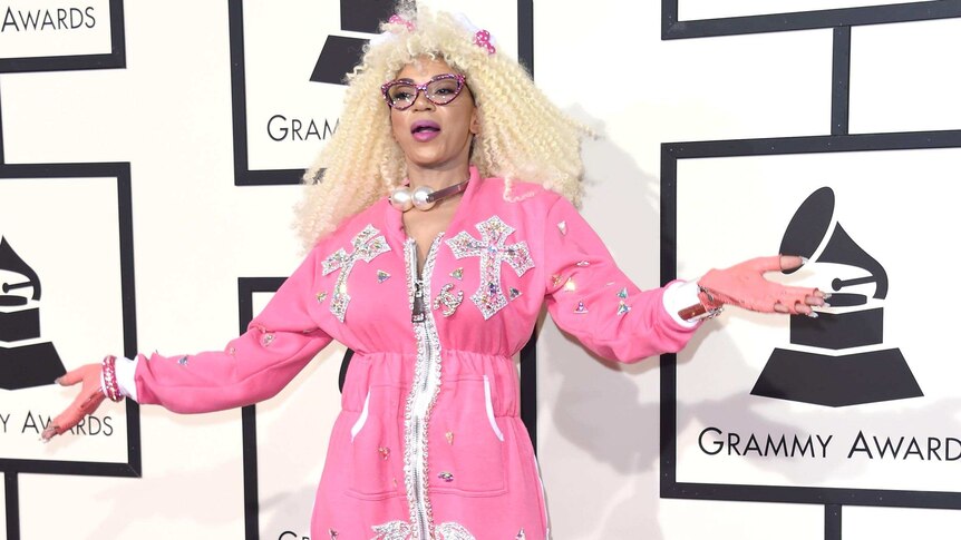Dencia on the red carpet wearing what looks like a pink jumpsuit.
