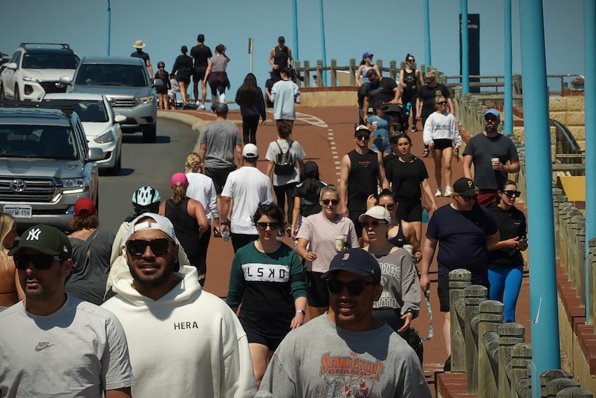 People grouped together on a busy coastal footpath