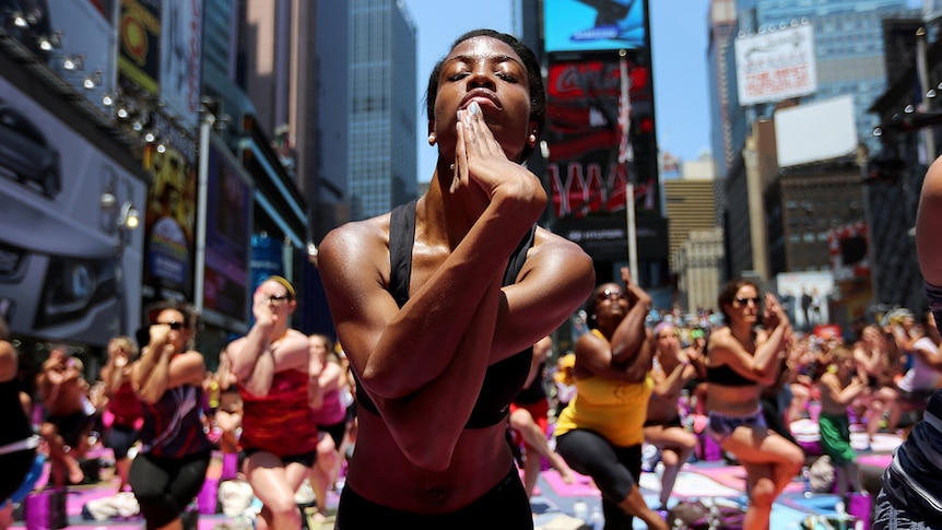 New Yorkers enjoy the sunshine during a mass yoga event in Times Square
