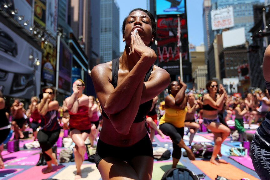 New Yorkers enjoy the sunshine during a mass yoga event in Times Square