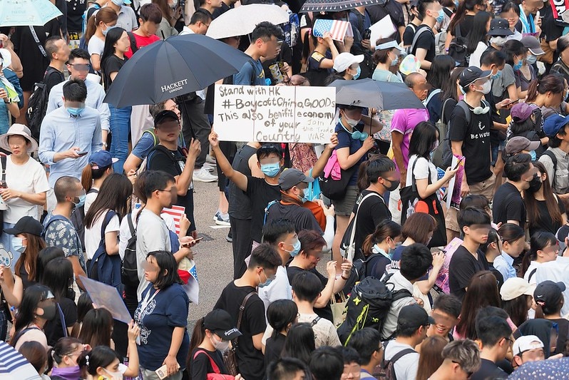 A crowd of protesters, some wearing surgical masks