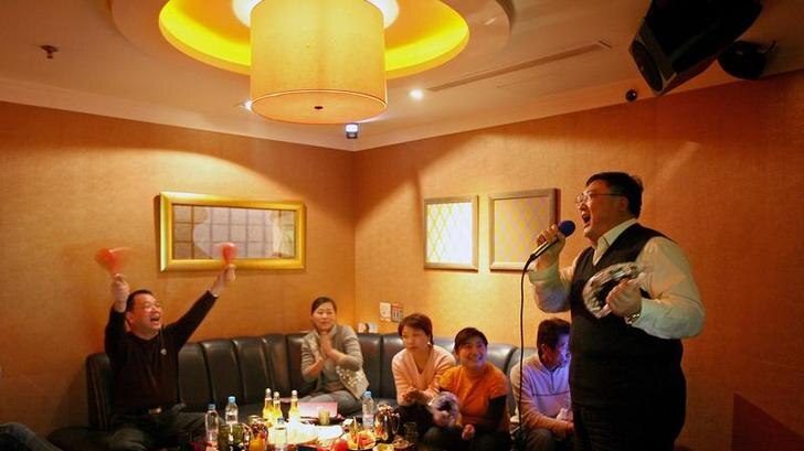 A group of Chinese friends entertain themselves at a Karaoke club