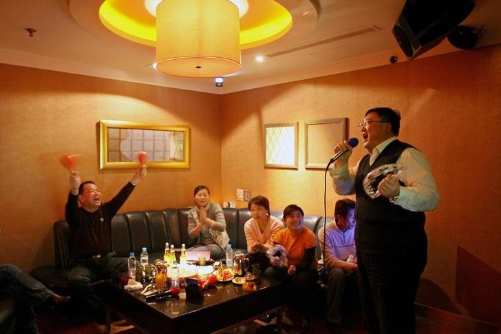 A group of Chinese friends entertain themselves at a Karaoke club