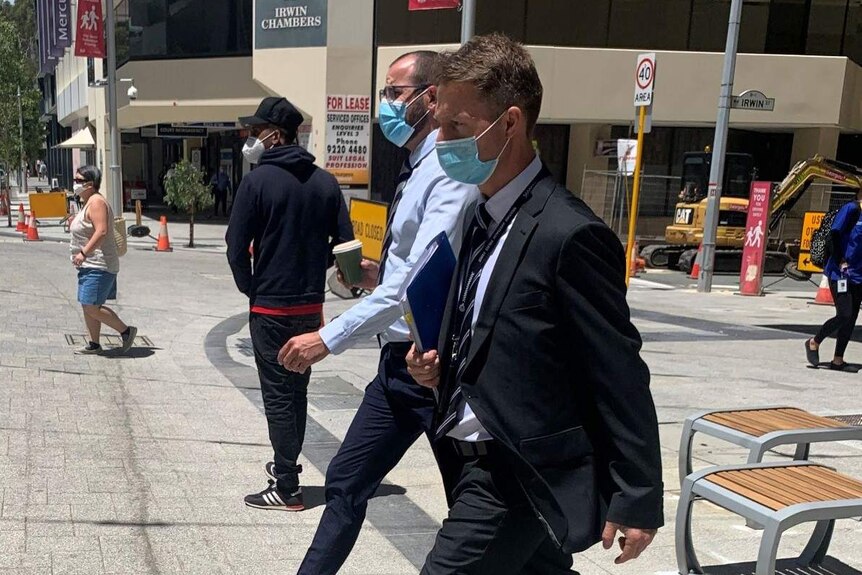 Detective Sergeant Tom Weidmann leaves court wearing a face mask and a suit.