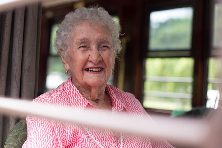 Edna Taylor smiles through the window as the scenic train departs its first stop on the way to Kuranda.