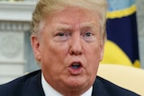 US President Donald Trump gestures while talking in the Oval Office.