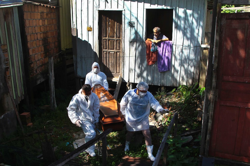 Public funeral service workers remove the body of 94-year-old woman who died from complications related to COVID-19.