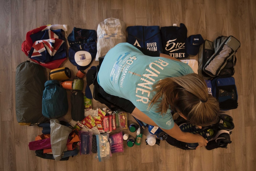 Contents of bag flat-laid on the floor: sleeping bag, energy pouches and spare shoes