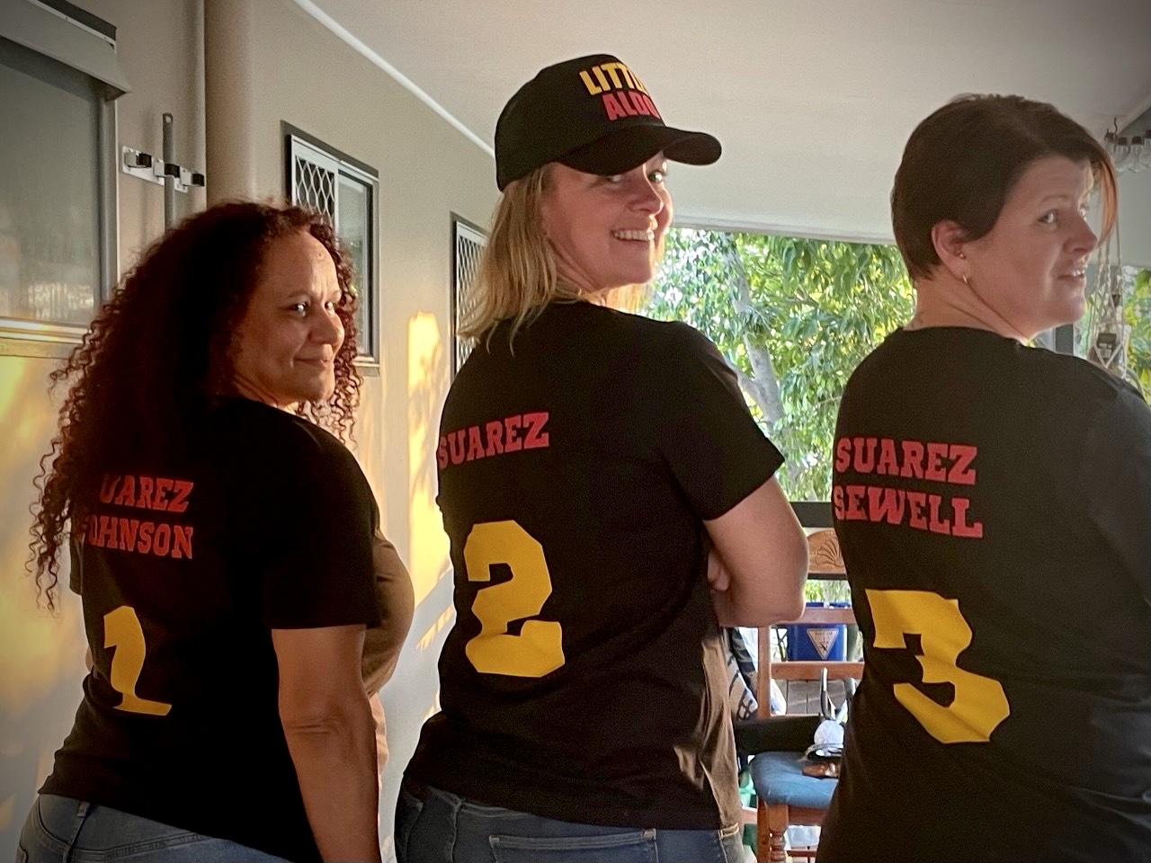 Three ladies in shirts with their names on them