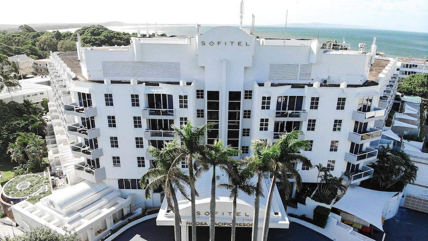 A white hotel with the ocean in the background