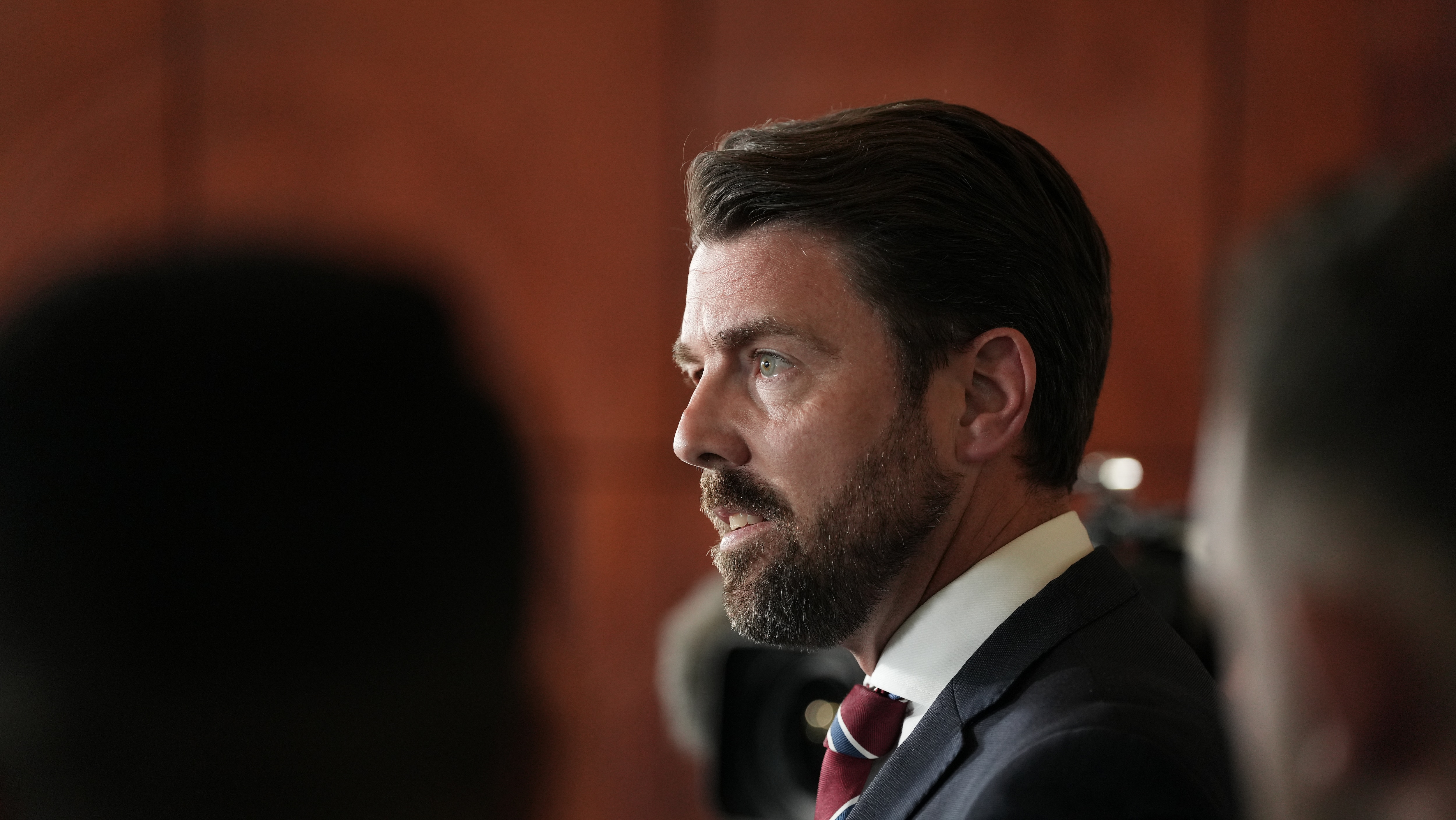 Side profile of Jonno Duniam in suit and tie.