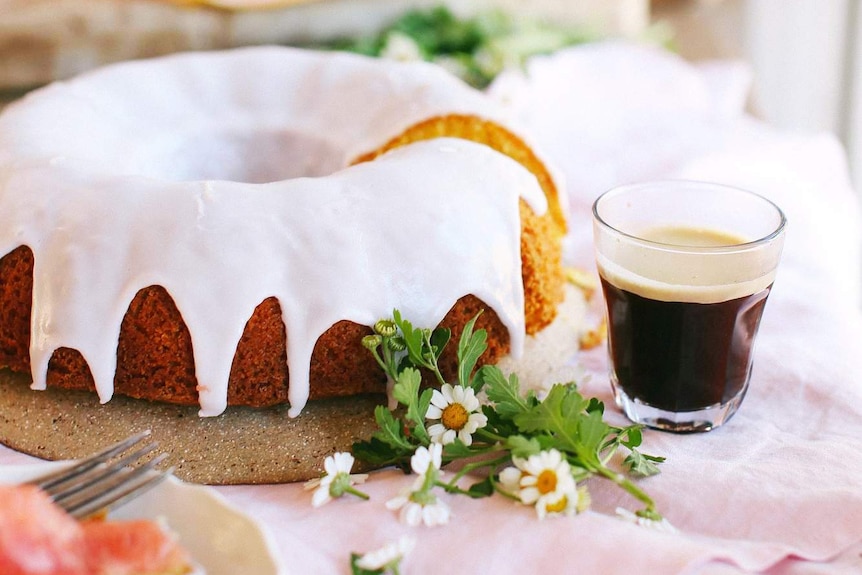 Iced pink grapefruit cake served with slices of grapefruit and coffee, illustrating our simple recipe.