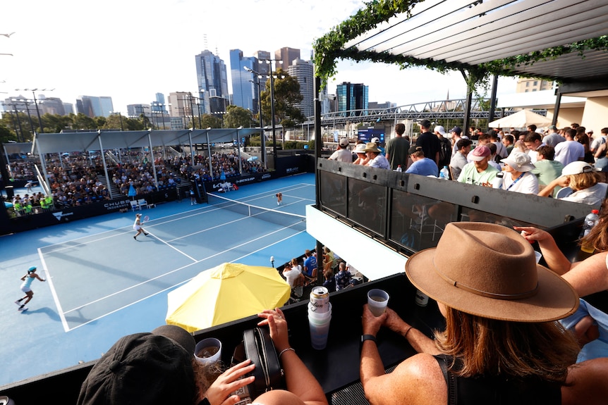 Spectators are pictured in the bar overlooking a doubles tennis match
