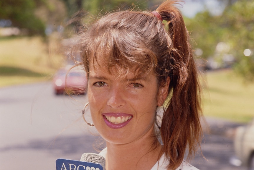 Young woman holding an ABC microphone and note book.