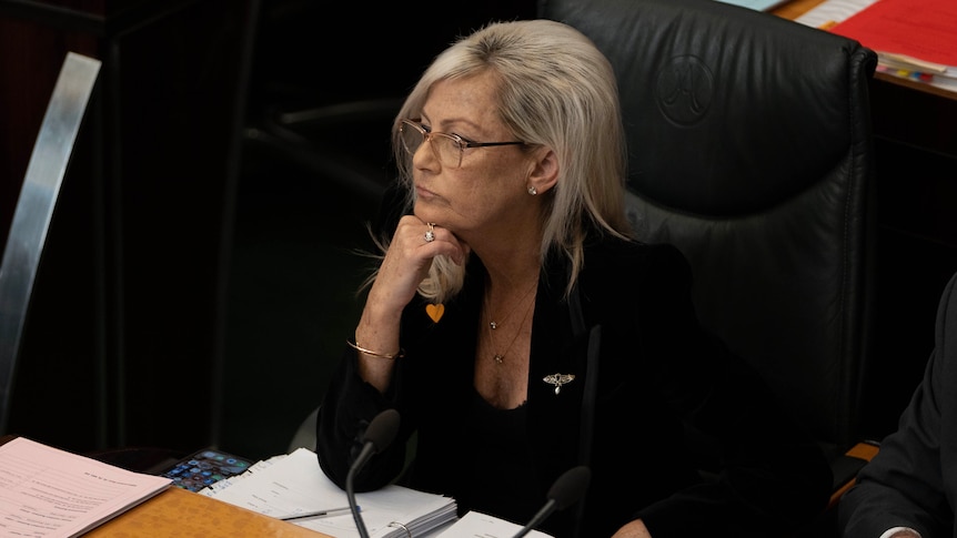 Elise Archer rests her head on her hand in parliament.