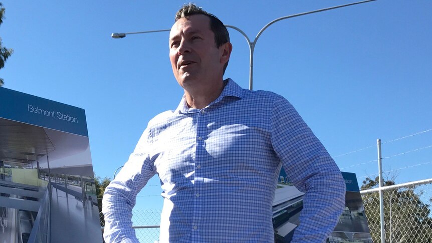 Mark McGowan stands with hands on hips.