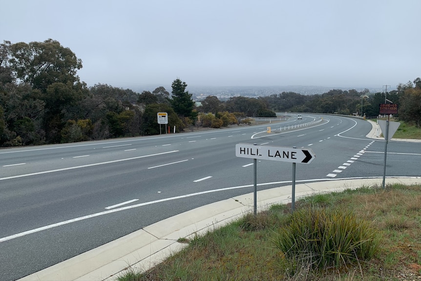 An intersection with a sign that says Hill Lane on an overcast day.