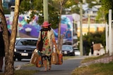 Woman wearing mask walks home with groceries in a street at Brisbane's West End before lockdown started.