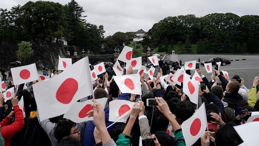 people waving Japanese flags.